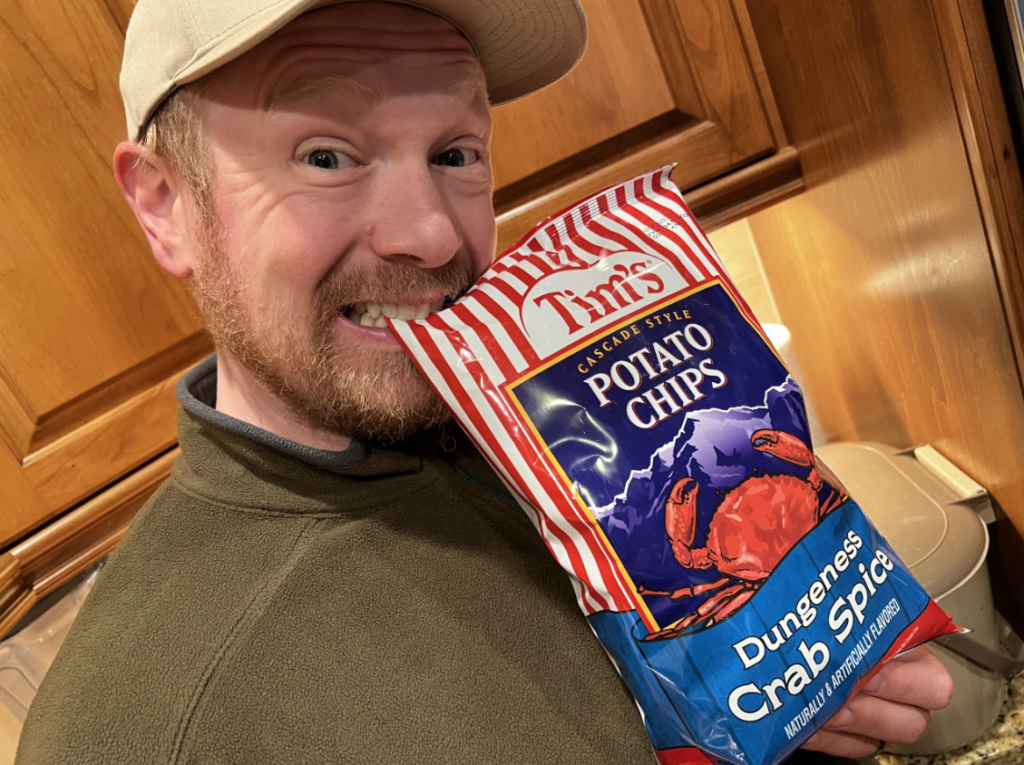 Will holding a bag of crab flavored potato chips.