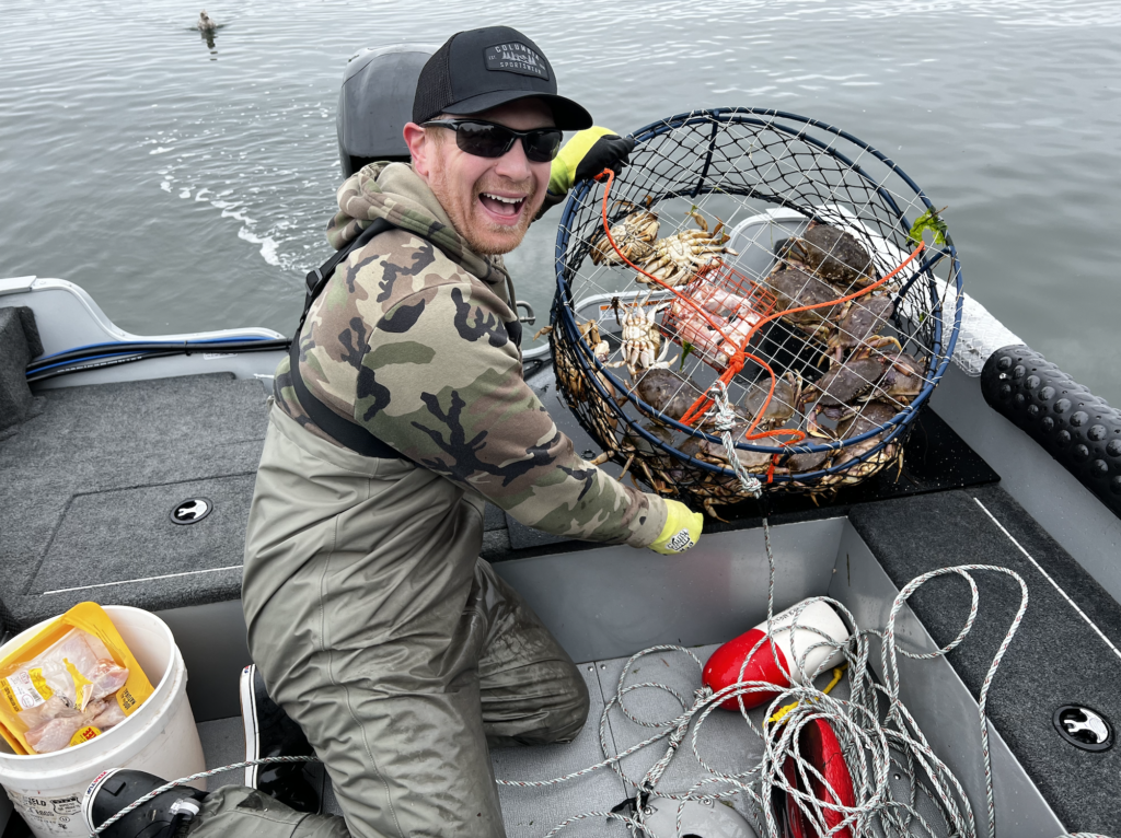 Will holding a crab pot full of Dungeness crab.
